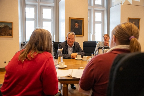 Oberbürgermeister Dr. Thomas Spies sitzt am Tisch im Magistratssitzungszimmer. Er unterhält sich mit zwei Bürgerinnen. © Patricia Grähling, Stadt Marburg