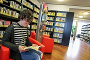 Eine Frau sitzt in der Stadtbücherei und liest.