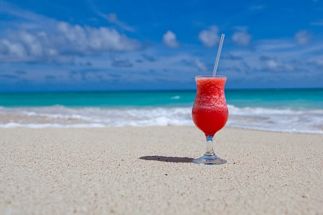 Strand mit blauem Himmel und einem roten Drink © Pixabay