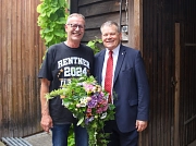 Oberbürgermeister Dr. Thomas Spies und Günter Krebs stehen nebeneinander. Krebs hält einen Blumenstrauß.